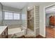 This bathroom includes a glass block shower enclosure and a bathtub, combining modern design and practical features at 4431 Palm Mesa Dr, Las Vegas, NV 89120