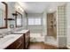 Bright bathroom with a double sink vanity, a bathtub, and a glass block shower enclosure offers style and functionality at 4431 Palm Mesa Dr, Las Vegas, NV 89120