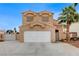 Two-story home with a two-car garage, tile roof, and desert landscaping with palm trees at 4431 Palm Mesa Dr, Las Vegas, NV 89120