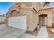 Close up of home's facade showing two car garage, front door and desert landscaping at 4431 Palm Mesa Dr, Las Vegas, NV 89120