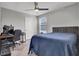Bedroom boasts a dark-blue comforter, a ceiling fan, and a small work-from-home office space at 4588 Swimming Minnow Ave, Las Vegas, NV 89141