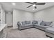 Comfortable living room features a ceiling fan, plush gray sectional, and neutral-toned carpet at 4588 Swimming Minnow Ave, Las Vegas, NV 89141