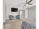 Spacious bedroom with two chairs, TV, ceiling fan and neutral tones at 4588 Swimming Minnow Ave, Las Vegas, NV 89141
