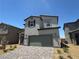 Two-story home featuring a gray stucco exterior, attached garage, and well manicured landscaping at 5180 Hisopo St # Lot 24, Las Vegas, NV 89122