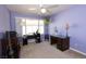 A well-lit bedroom provides ample space for desks, storage, and a guitar at 5206 Mandalay Springs Dr # 204, Las Vegas, NV 89120