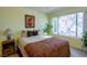 Bright bedroom enhanced by natural light from a large window showcasing outside greenery at 5206 Mandalay Springs Dr # 204, Las Vegas, NV 89120