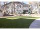 Two-story complex building with green grass and mature trees at 5206 Mandalay Springs Dr # 204, Las Vegas, NV 89120