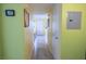 Neutral hallway with tile flooring, soft yellow walls, decorative wall art, and a storage area at 5206 Mandalay Springs Dr # 204, Las Vegas, NV 89120