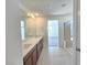 Bright bathroom featuring dual sinks, granite countertops, wood cabinets, and walk-in shower at 5748 Avondale Rise Way, Las Vegas, NV 89141