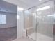 Modern bathroom with glass-enclosed shower and seating, with view to carpeted room at 5748 Avondale Rise Way, Las Vegas, NV 89141