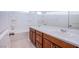 Bright bathroom featuring a double sink vanity, tub, and shower combo at 5748 Avondale Rise Way, Las Vegas, NV 89141