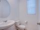 Small bathroom with a pedestal sink, toilet, and window for natural light at 5748 Avondale Rise Way, Las Vegas, NV 89141