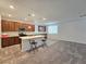 Modern kitchen featuring dark wood cabinetry, a white island with bar seating, and tile floors adjacent to the living area at 5748 Avondale Rise Way, Las Vegas, NV 89141