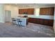 Open-concept kitchen with dark cabinets, a white island, and stainless steel appliances, seamlessly connecting to the living area at 5748 Avondale Rise Way, Las Vegas, NV 89141
