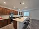 A modern kitchen features dark wood cabinets, stainless steel appliances, and a white countertop island with seating at 5748 Avondale Rise Way, Las Vegas, NV 89141