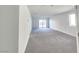 Spacious, bright living room featuring neutral carpeting, white walls, and a sliding glass door to the backyard at 5748 Avondale Rise Way, Las Vegas, NV 89141