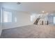 Spacious living room featuring stairs, multiple windows and carpet at 5748 Avondale Rise Way, Las Vegas, NV 89141