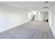 Bright, spacious living room with neutral carpeting, white walls, and staircase access to the upper level at 5748 Avondale Rise Way, Las Vegas, NV 89141