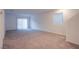 Large, bright living room with neutral carpet, sliding glass door, and a large window at 5748 Avondale Rise Way, Las Vegas, NV 89141