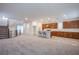 Spacious open floor plan featuring carpeted living area, stairs, and a kitchen with an island at 5748 Avondale Rise Way, Las Vegas, NV 89141