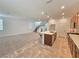 Open-concept living space features a kitchen with an island, a cozy living area with carpet, and a staircase at 5748 Avondale Rise Way, Las Vegas, NV 89141