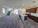 A spacious living area flows into a kitchen with dark wood cabinets, a white island, and stairs leading upstairs at 5748 Avondale Rise Way, Las Vegas, NV 89141