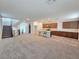 Spacious open floor plan with tile and carpet flooring, showcasing a kitchen island and a staircase to the upper level at 5748 Avondale Rise Way, Las Vegas, NV 89141
