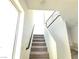Modern staircase with sleek railings and natural light streaming through the large window at 5748 Avondale Rise Way, Las Vegas, NV 89141