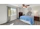 Cozy bedroom featuring plush carpet, ceiling fan, and bright natural light from the window at 6217 Muirlands Ct, Las Vegas, NV 89130