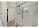 Sleek walk-in shower with white tile, glass door, and black hardware at 6217 Muirlands Ct, Las Vegas, NV 89130