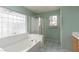 Bathroom featuring a bathtub, shower, vanity, and window with privacy glass at 6440 Break Point Ave, Las Vegas, NV 89130