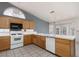 Well-lit kitchen features tile floors, ample cabinet space, white appliances, and a ceiling fan at 6440 Break Point Ave, Las Vegas, NV 89130