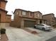 Two-story home with a two-car garage and front yard, showcasing its architectural design and curb appeal at 668 Moonlight Stroll St, Henderson, NV 89002