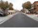 A neighborhood street with mature trees lining the street, sidewalks, and well-maintained homes at 668 Moonlight Stroll St, Henderson, NV 89002