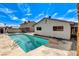 Beautiful in-ground pool with ample space for outdoor lounging, set against a backdrop of a single-story home at 6782 Bonillo Dr, Las Vegas, NV 89103