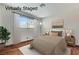 This virtually staged bedroom features a cozy bed, a window, and wood-look floors at 6782 Bonillo Dr, Las Vegas, NV 89103