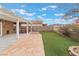 Spacious backyard with a covered patio, artificial grass, and stone walkway at 7904 Mountain Point Ave, Las Vegas, NV 89131