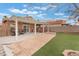 Expansive backyard with a covered patio, stone pavers, and artificial turf at 7904 Mountain Point Ave, Las Vegas, NV 89131