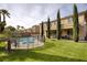 Large backyard features a pool, grass, and a home exterior with beautiful landscaping at 8425 Cambrils Ave, Las Vegas, NV 89178