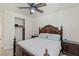 Bedroom with dark wood bed, ceiling fan, and closet at 8425 Cambrils Ave, Las Vegas, NV 89178