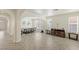 Spacious dining room with arched entrances, decorative chandelier, neutral color palette, and wood-look tile flooring at 8425 Cambrils Ave, Las Vegas, NV 89178