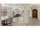 Inviting dining room with arched entrances, a decorative chandelier, neutral color palette, and wood-look herringbone tile flooring at 8425 Cambrils Ave, Las Vegas, NV 89178