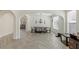 Bright dining room featuring arched entrances, a decorative chandelier, neutral color palette, and wood-look herringbone tile flooring at 8425 Cambrils Ave, Las Vegas, NV 89178