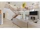 Open concept living room with fireplace, staircase, railing and comfortable sectional sofa at 8425 Cambrils Ave, Las Vegas, NV 89178