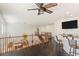 Open loft area with dark wood floors, ceiling fan, and a wet bar area at 8425 Cambrils Ave, Las Vegas, NV 89178