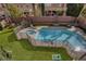Aerial view of a fenced pool and spa in a backyard with artificial grass, cornhole game in the corner at 8425 Cambrils Ave, Las Vegas, NV 89178