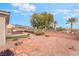 Landscaped backyard featuring desert plants, a built-in grill, and a low stone wall at 8506 River Ridge Dr, Las Vegas, NV 89131