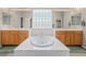 Bathroom featuring double sinks, soaking tub, and glass block window at 8506 River Ridge Dr, Las Vegas, NV 89131