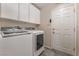 Well-lit laundry room featuring a modern washer and dryer and ample cabinet space for storage at 8506 River Ridge Dr, Las Vegas, NV 89131