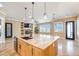 Open concept kitchen island with a sink, seating and generous counter space with living room in the background at 8509 Iron Mountain Rd, Las Vegas, NV 89143